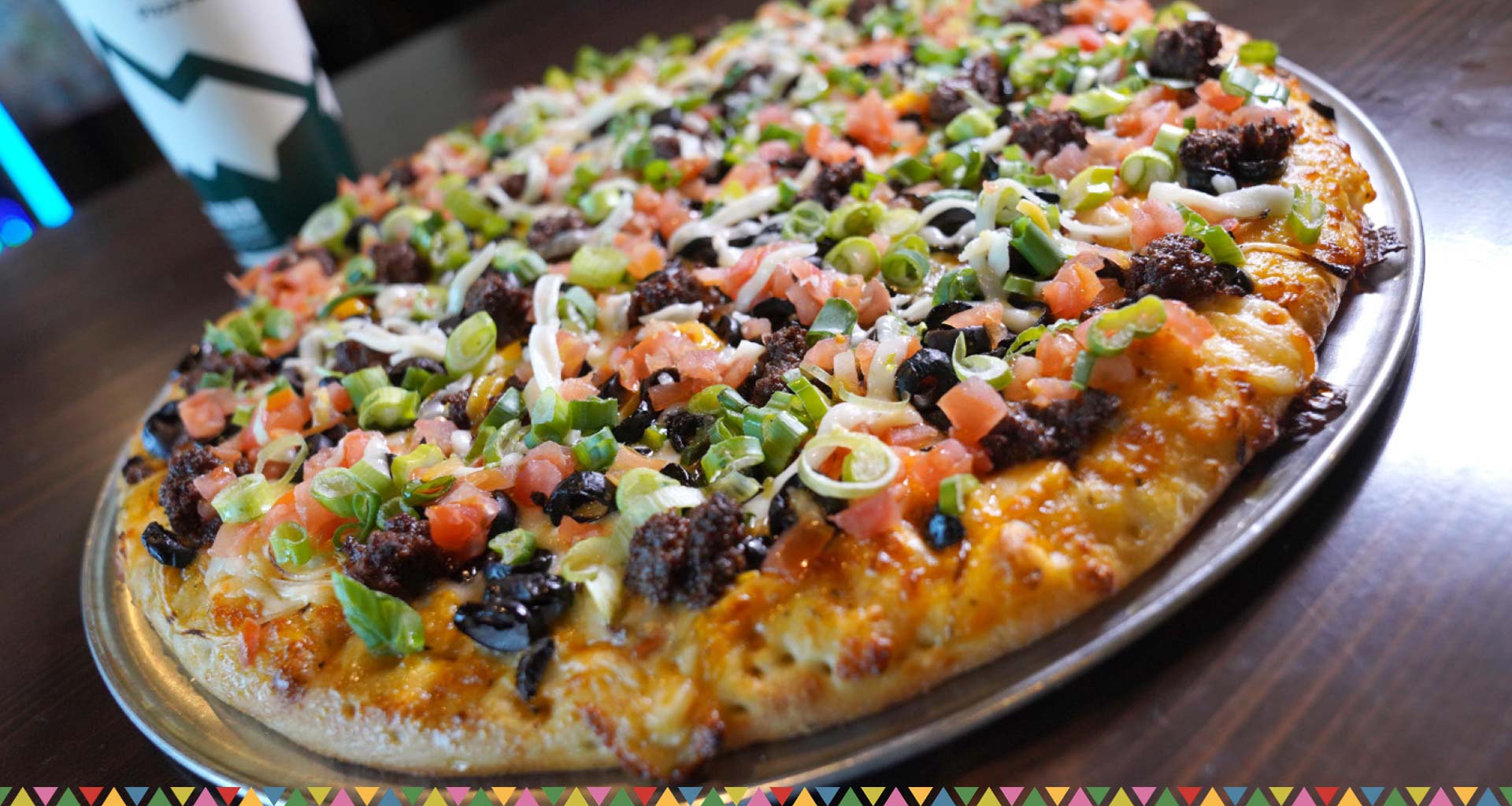 Fiesta Taco Pizza topped with taco-seasoned beef, veggies, and Jalapeño Cheese-Tomatillo Serrano Sauce Fiesta Taco Pizza topped with taco-seasoned beef, veggies, and Jalapeño Cheese-Tomatillo Serrano Sauce