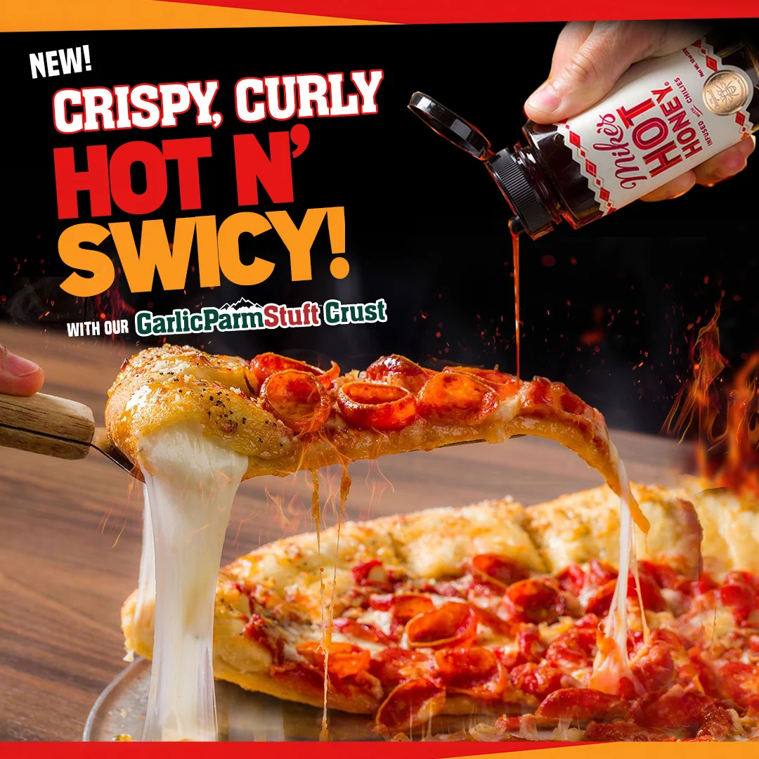New Crispy, Curly Hot N’ Swicy, with our GarlicParmStuft: a slice of pepperoni pizza with a long cheese pull and Mike’s Hot Honey being poured over it